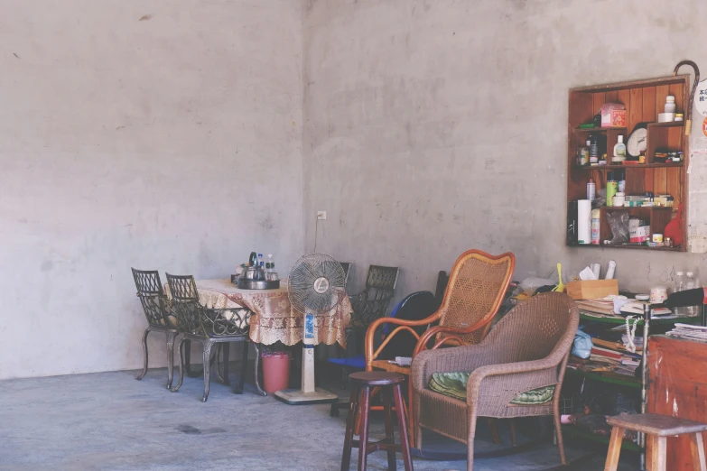 a room full of chair and ottomans with bookshelves on the wall