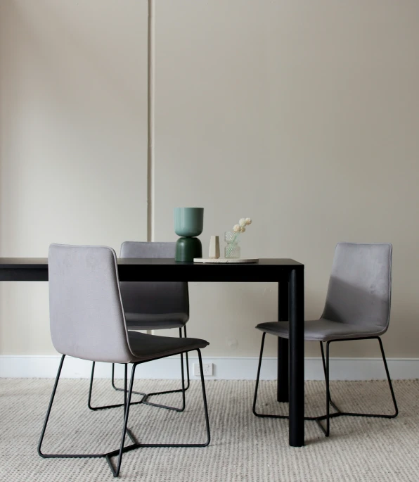 a black table and chairs are shown against the wall