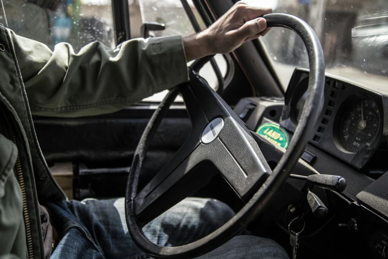 a man holding the steering wheel of a tractor