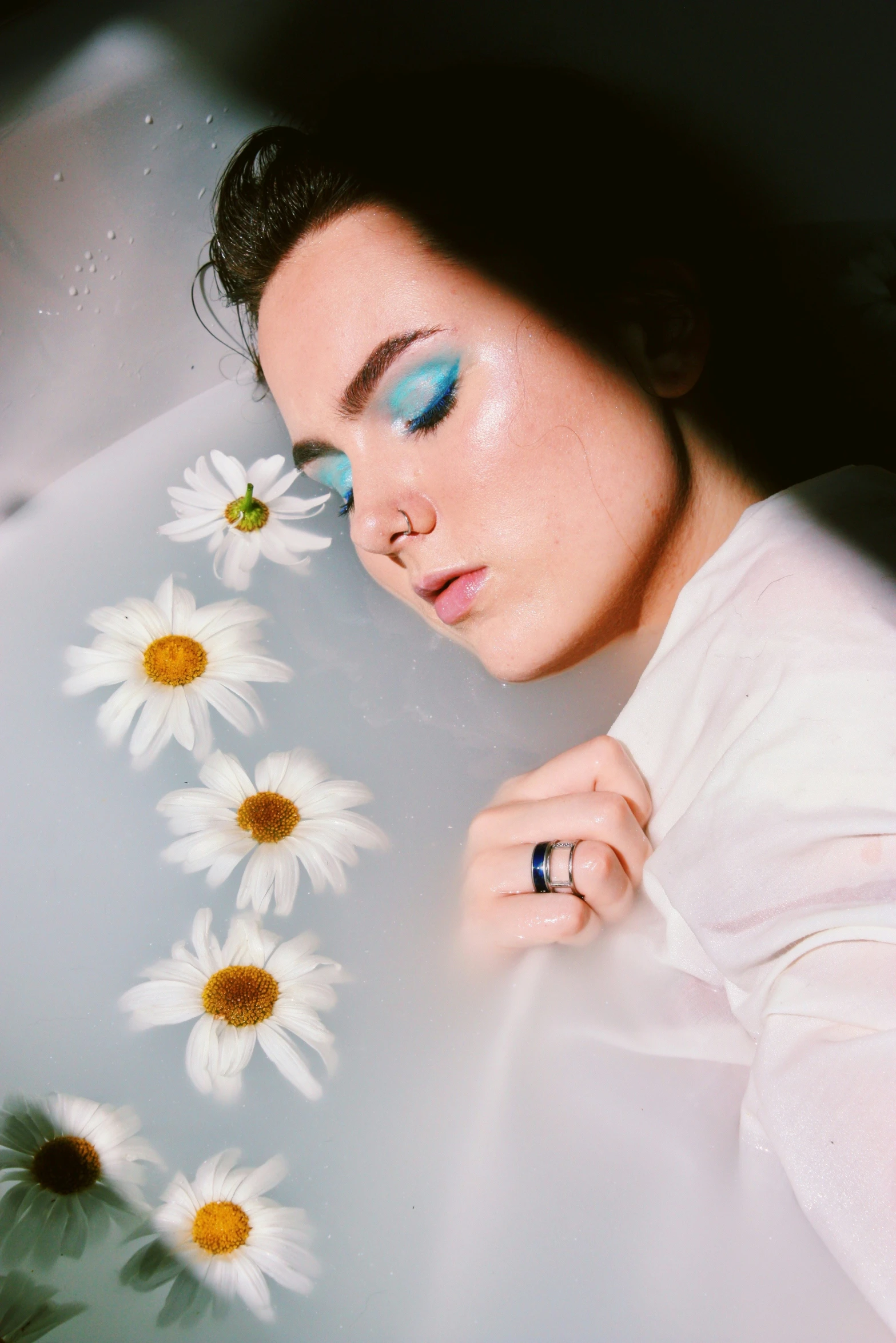 a woman taking a bubble bath with daisies on the side