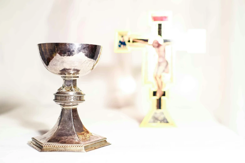 a pew is displayed in front of an empty crucifix