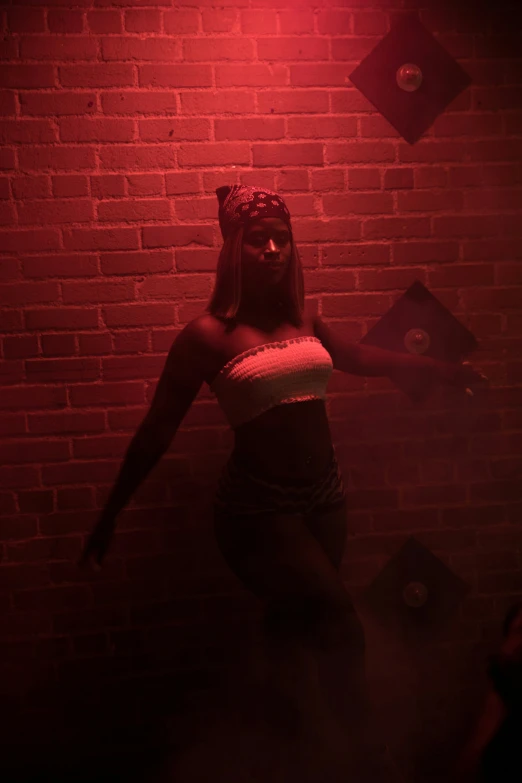 a girl wearing a blindfold is shown in red light
