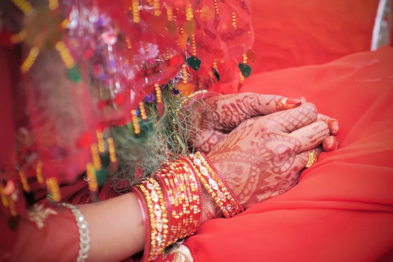 hands of two people and a red cloth covered in garland