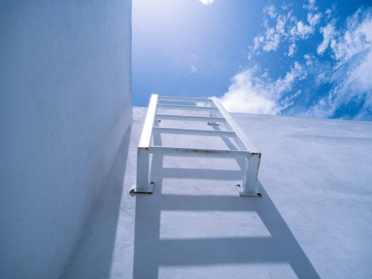 there is a white ladder extending upwards into the sky