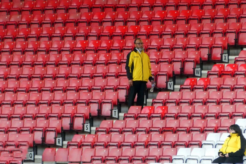 the man is walking on some stairs of red and white bleachers