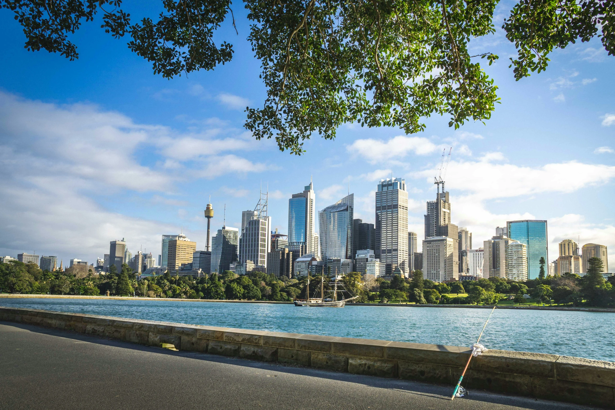 the cityscape of a large, modern city next to a blue body of water