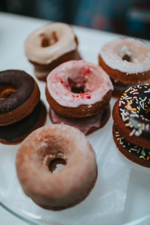 several different donuts sit on top of a glass plate