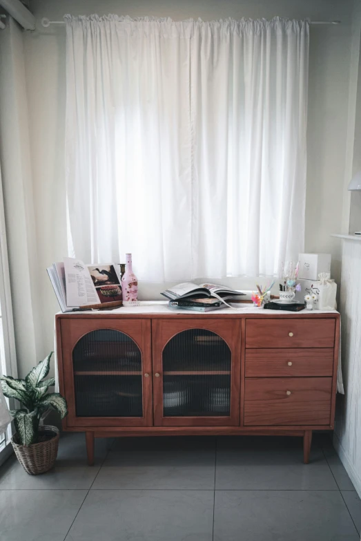 a sideboard on the floor of a kitchen near a window