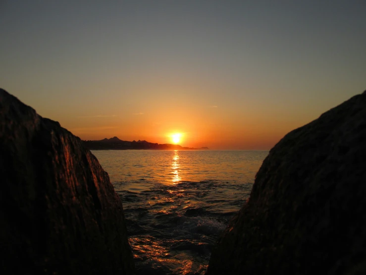 a sunset taken from a rocky shoreline