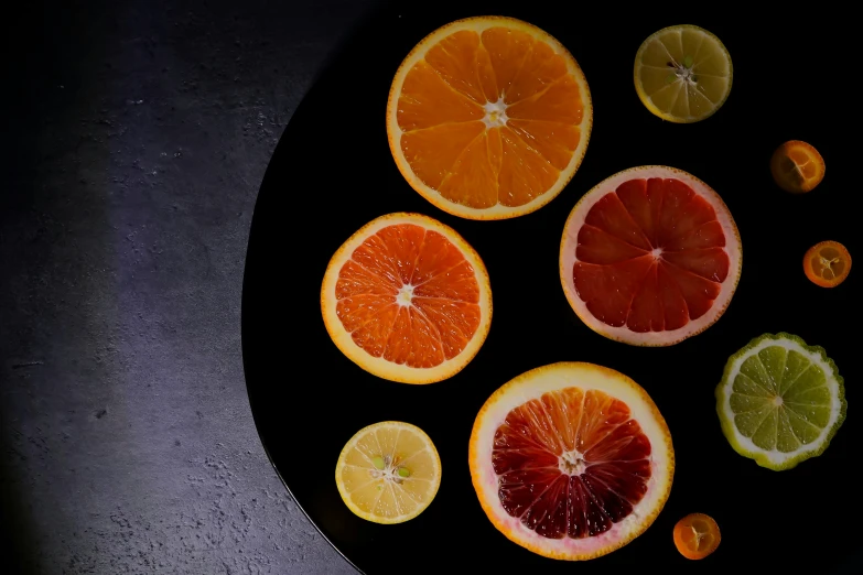 various fruit cut in to pieces on a black plate