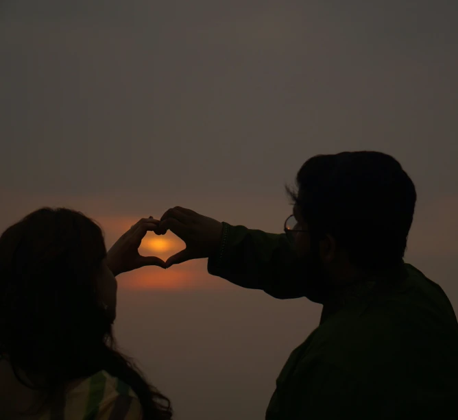 the man and woman are looking at the sunset