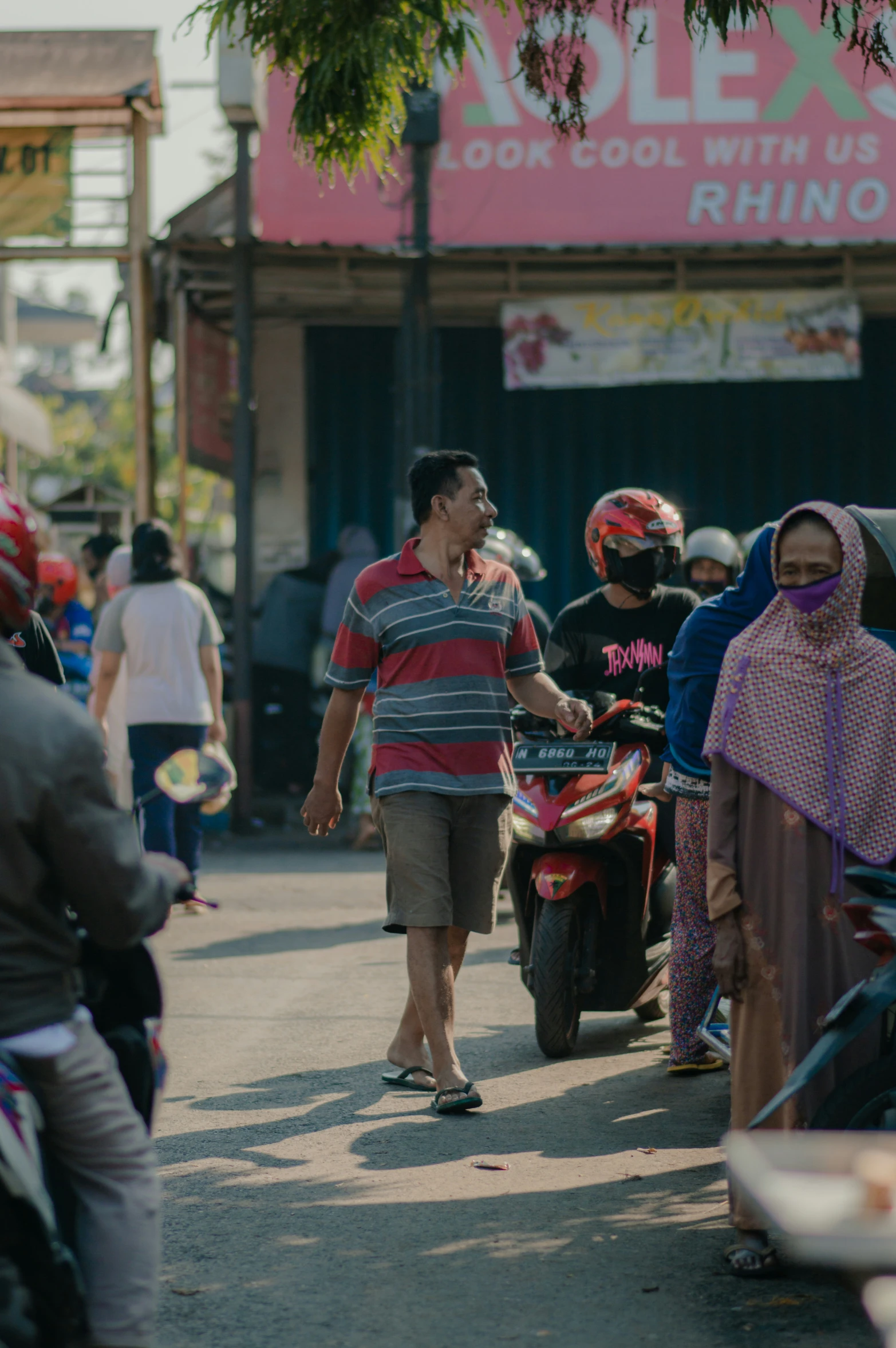 a man walking along a street talking on a cellphone