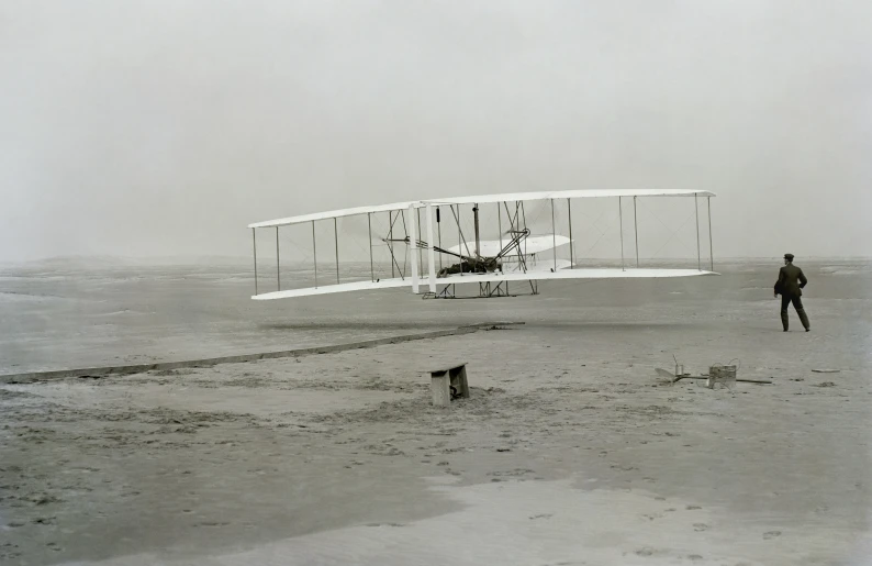 a person standing next to an old biplane