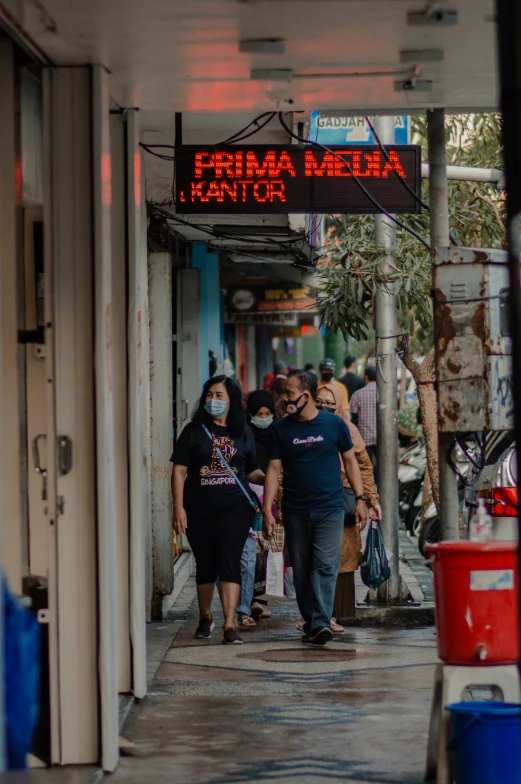 several people wearing face masks walk down a street