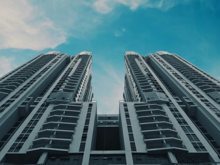 looking up at two very tall skyscrs from the ground