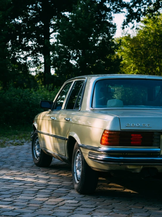 the car is sitting on a cobblestone parking lot