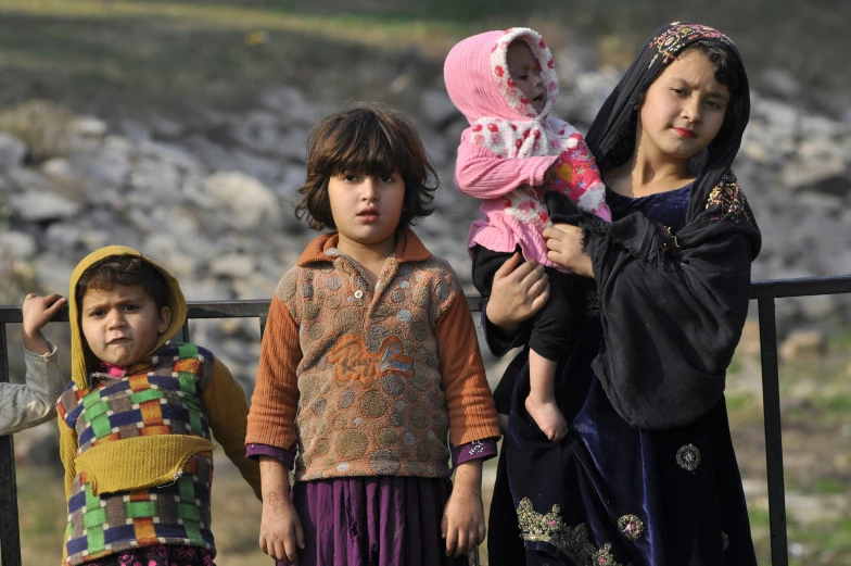 three little children standing near each other