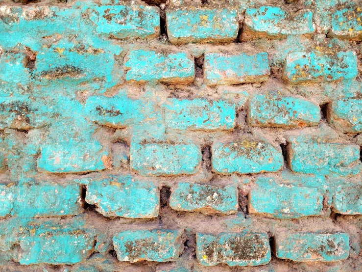 a brick wall with brown and turquoise paint