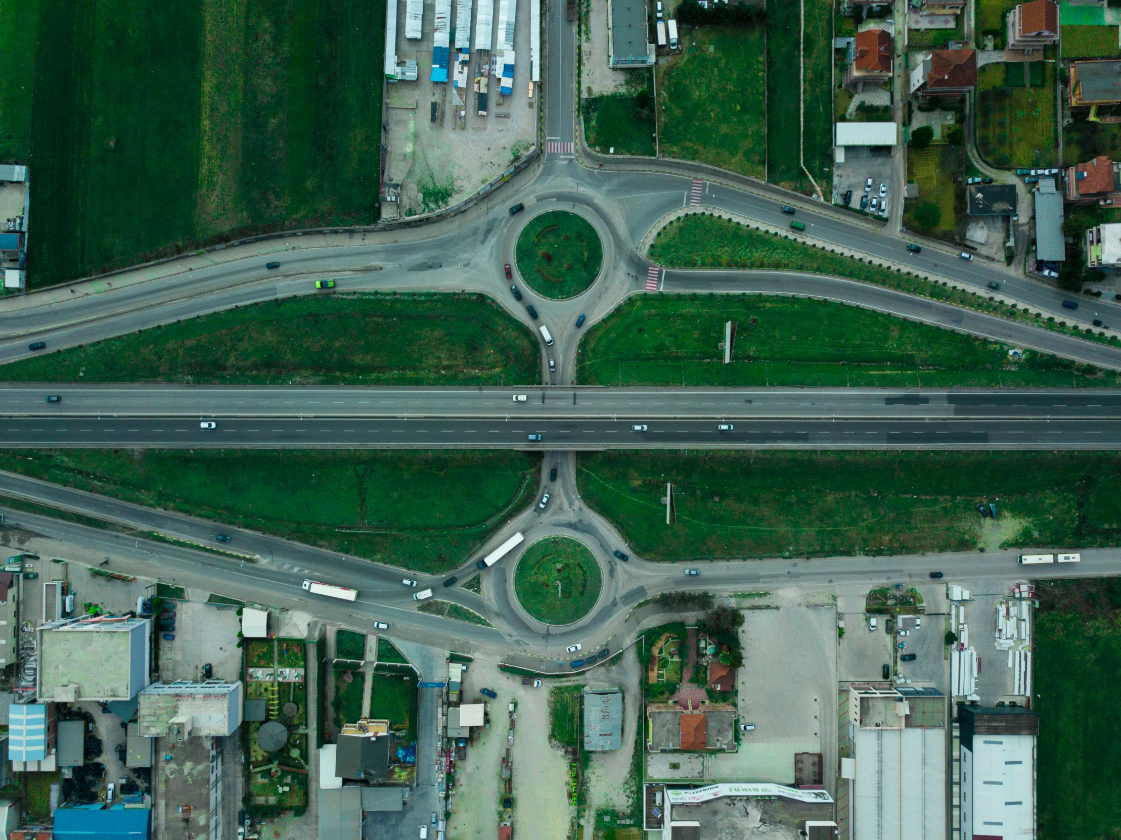 a road intersection made of multiple roads and green fields