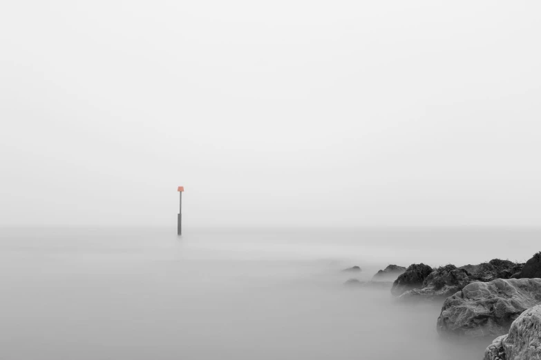 a red light sitting on top of a pier near the ocean