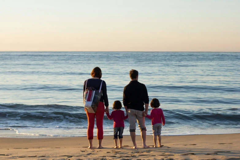 a family with two children standing on a beach