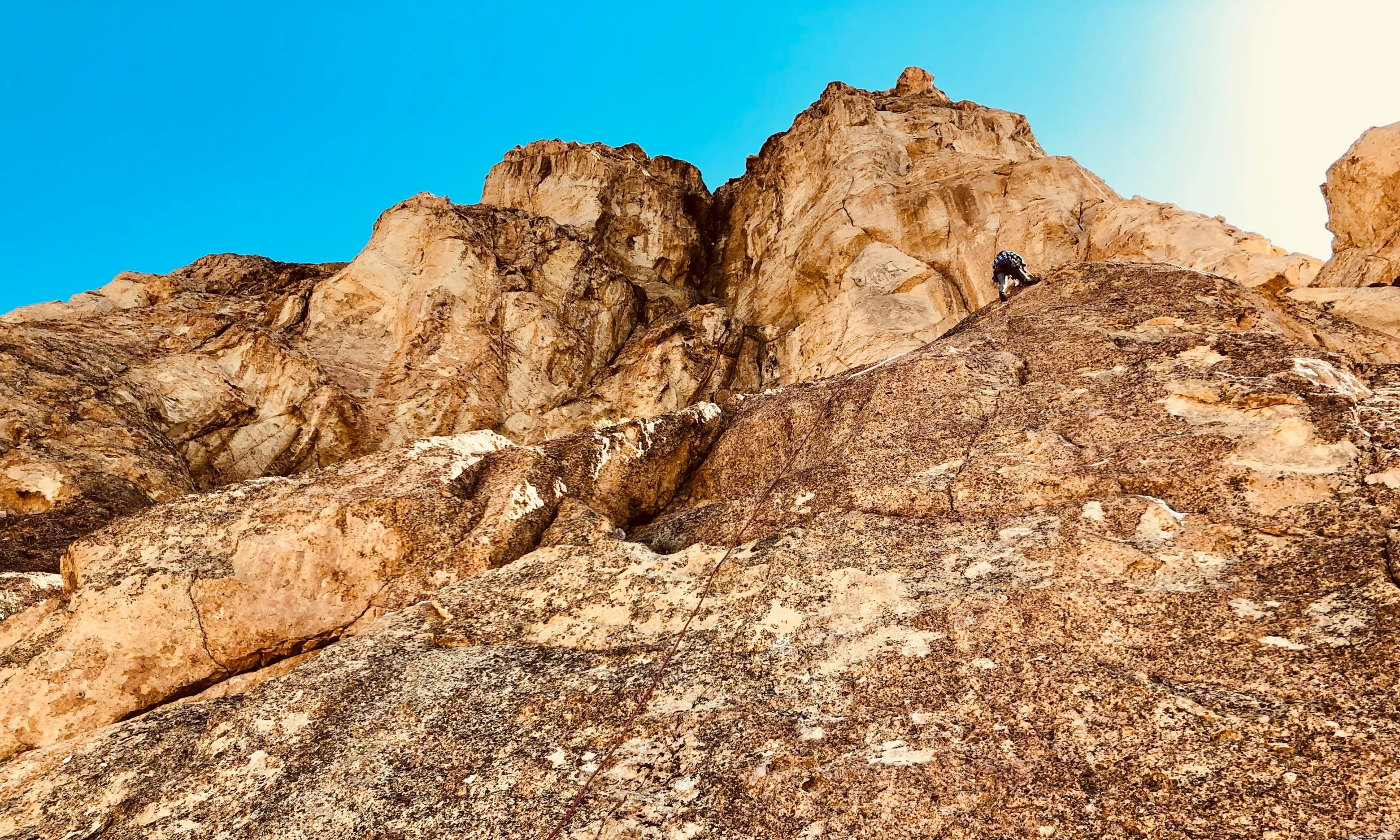 some brown rocks and a person climbing on the top