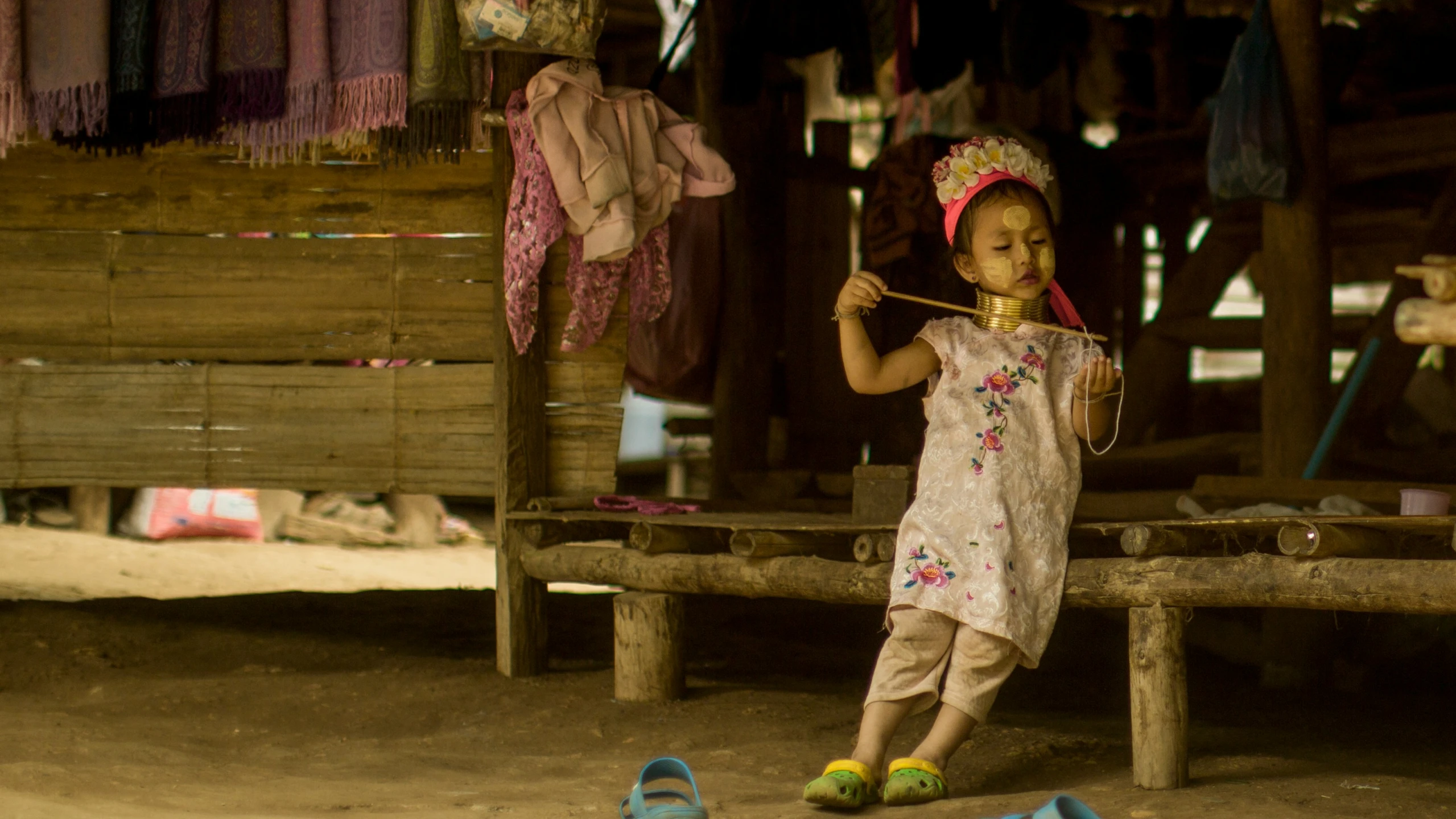 a little girl standing next to her clothes and clothing