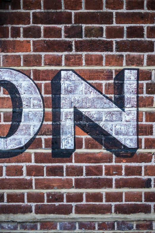 brick wall with a stenciled sign and letters in different languages