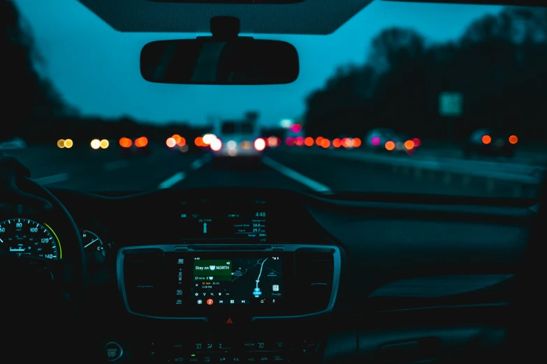 the view from behind a car at night on the dashboard of a vehicle