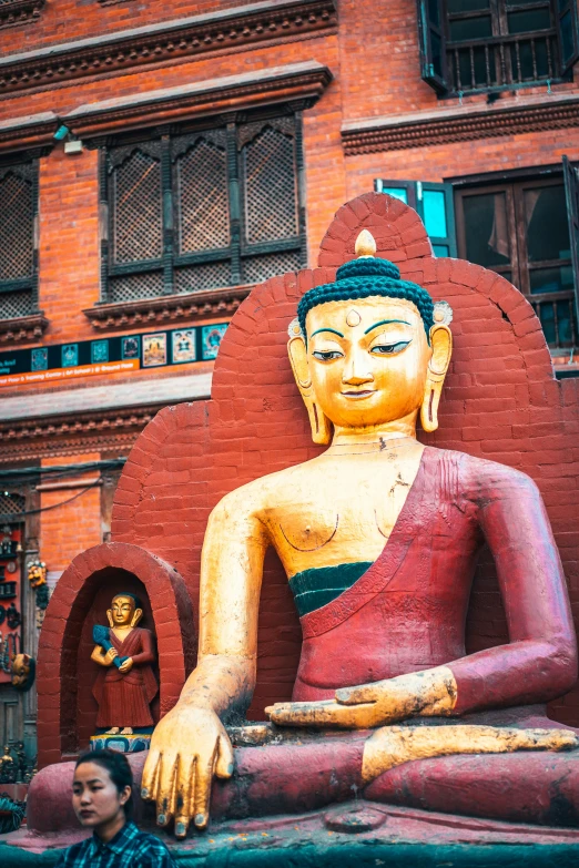 statue sitting outside in front of red brick building