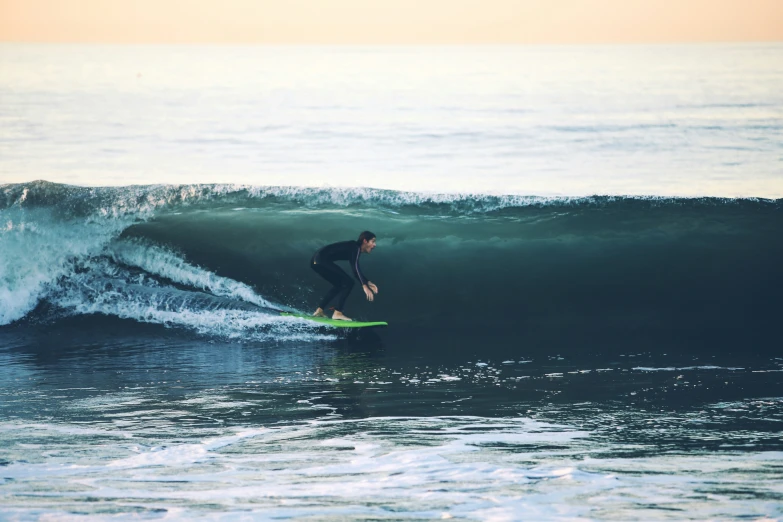 man surfs in an ocean wave while surfing