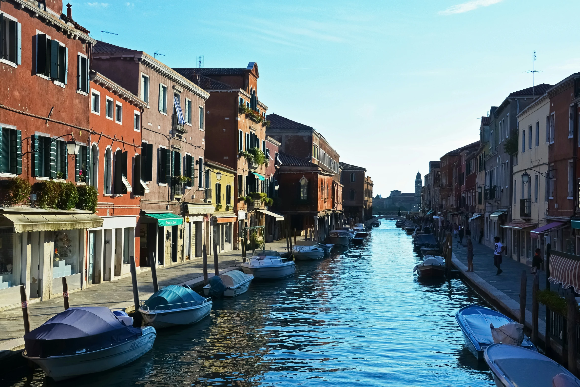 the small boats are lined up beside the canals