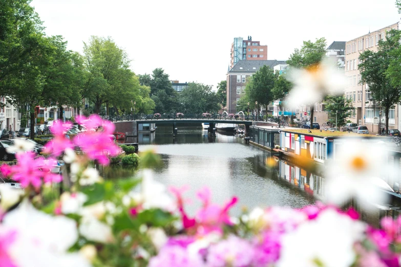 several boats are floating on a canal near buildings