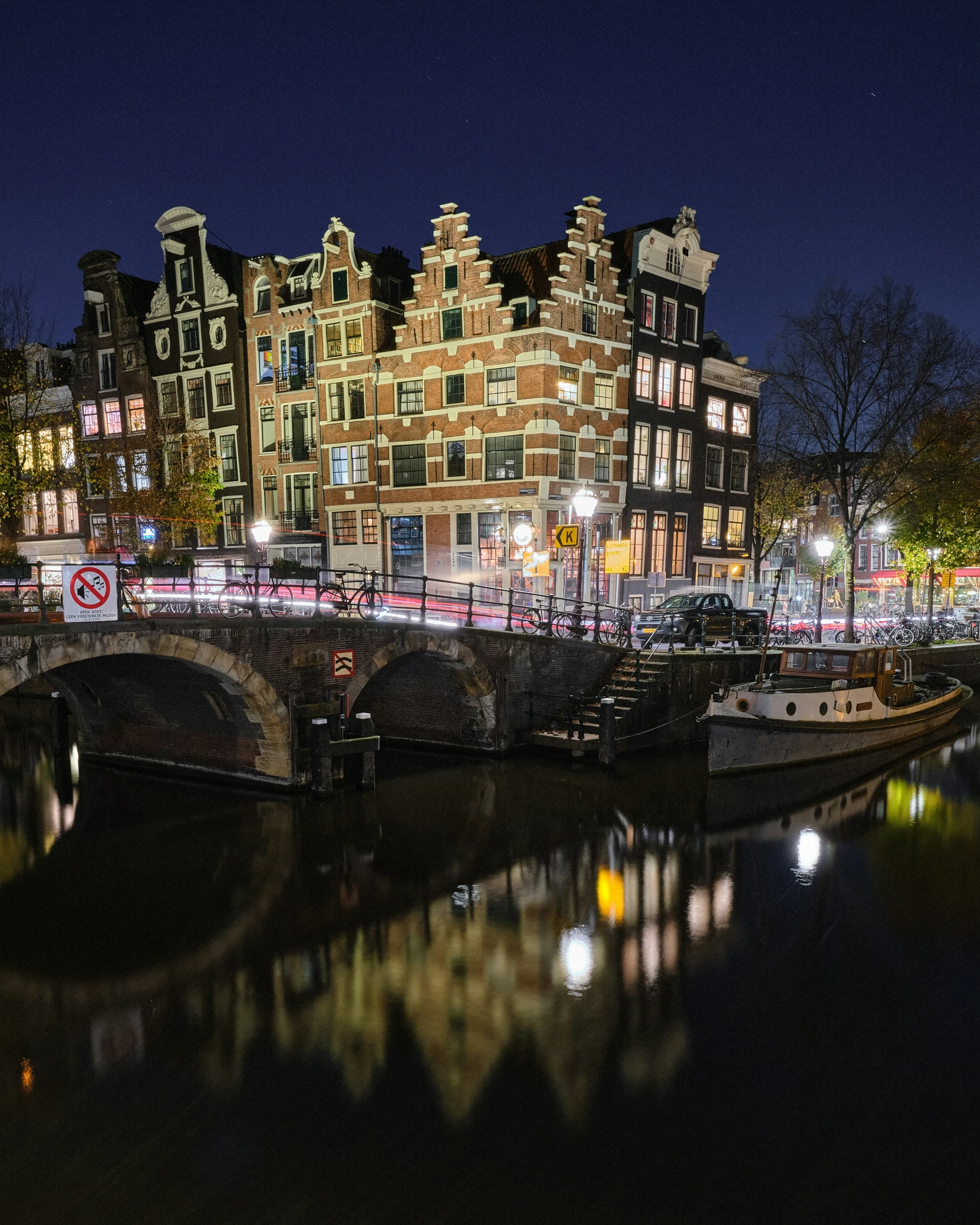 a city skyline shows the old houses and boats, which are reflected in the water