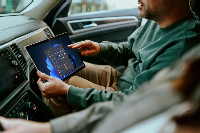 a man using an ipad while sitting in his car