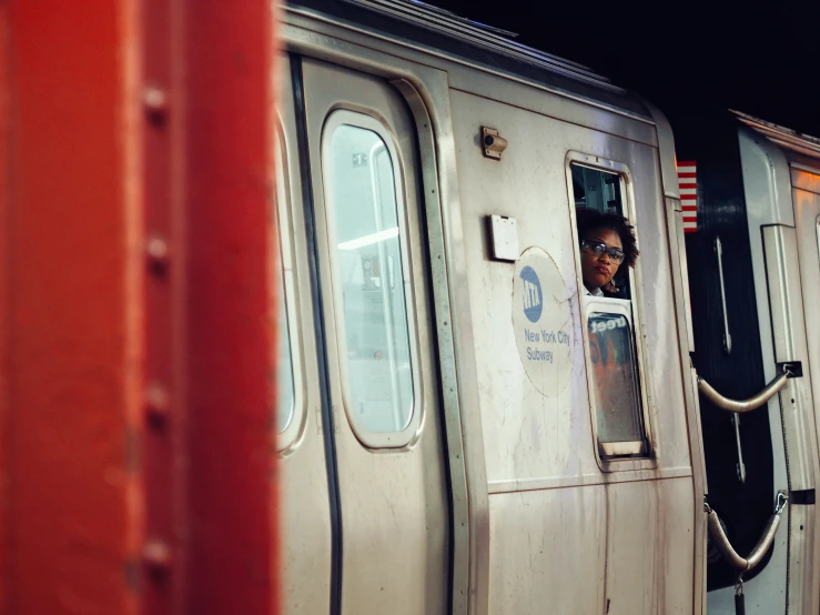 a girl peeks out the window of a train