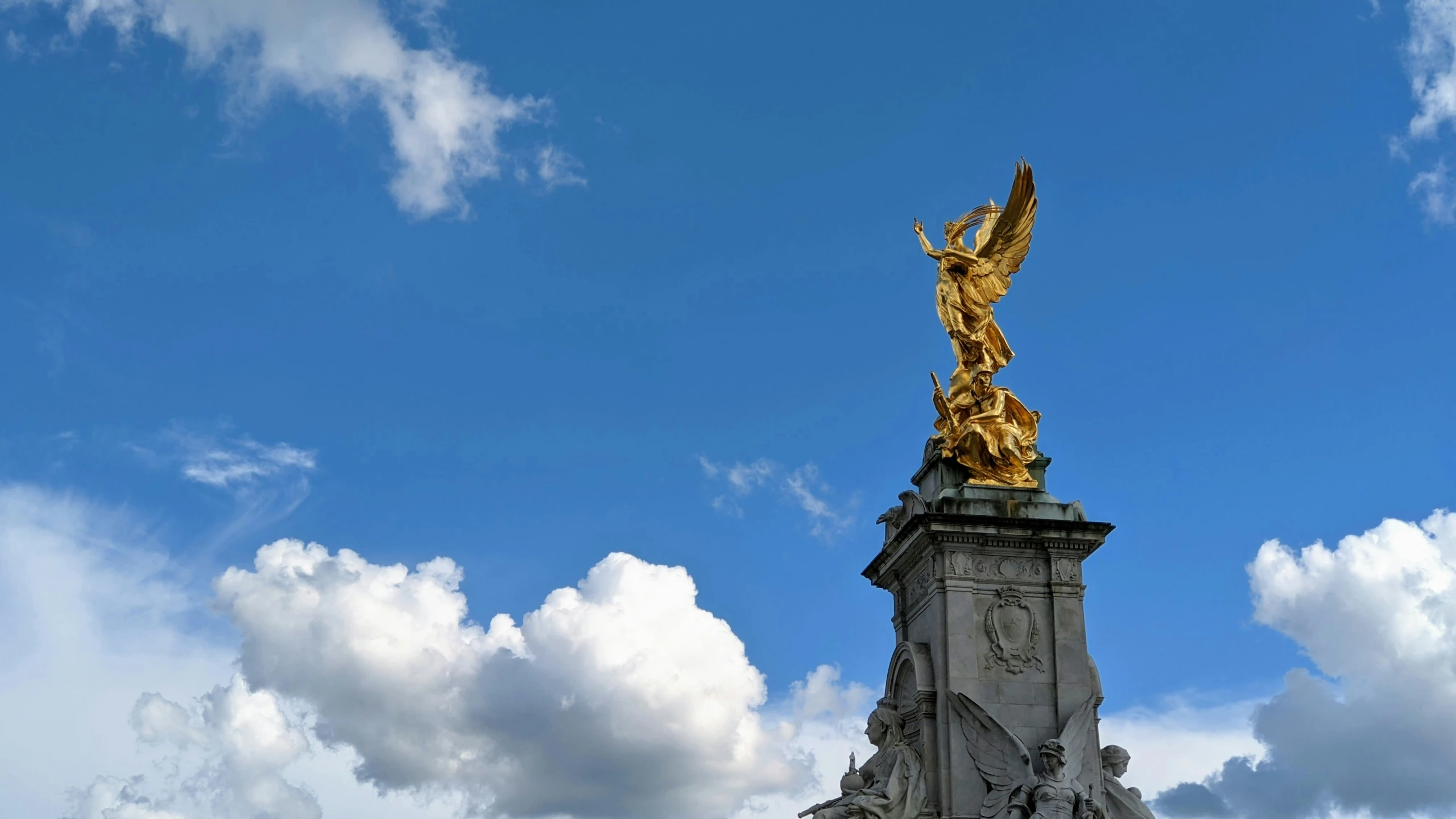 a tall golden statue with a winged decoration