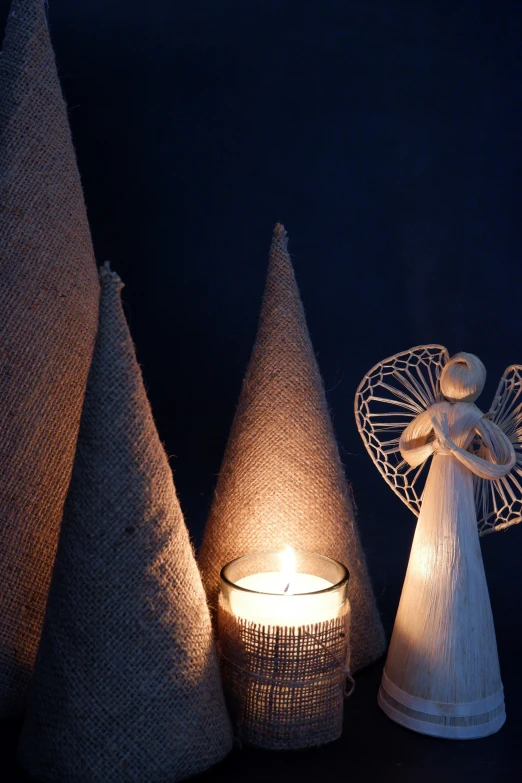 an angel sitting on top of a wire next to two christmas trees