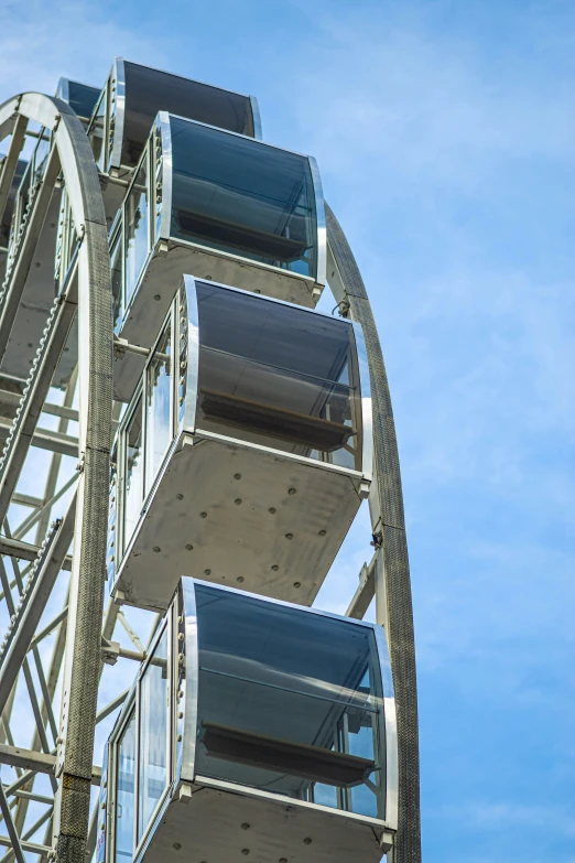 an airplane flying in the blue sky next to a tall ferris wheel