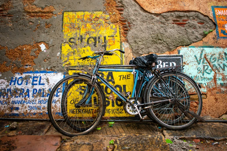 a bike parked against a wall covered in street signs