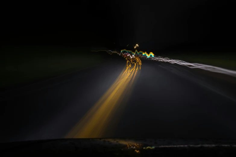a person riding their motorcycle on a dark road at night