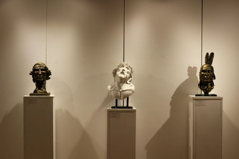 a group of sculptures on pedestals in an art gallery