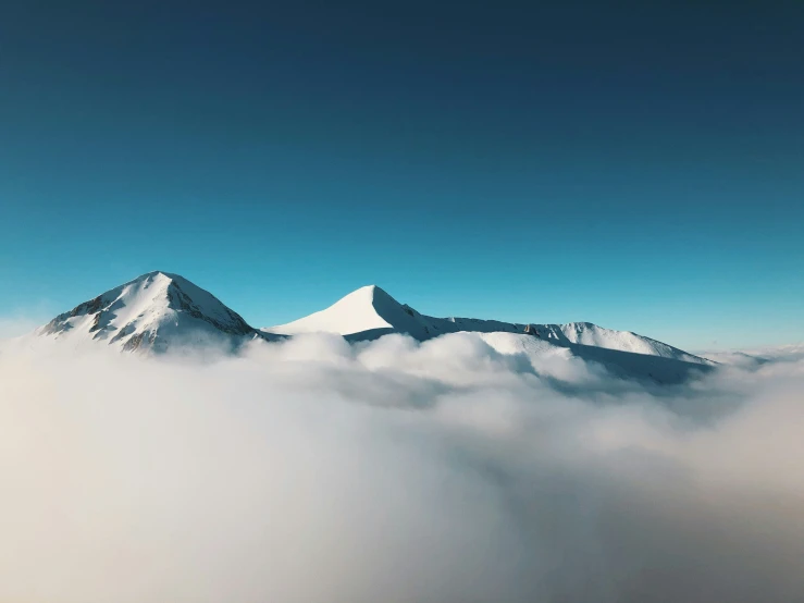 a couple of tall mountains covered in white clouds