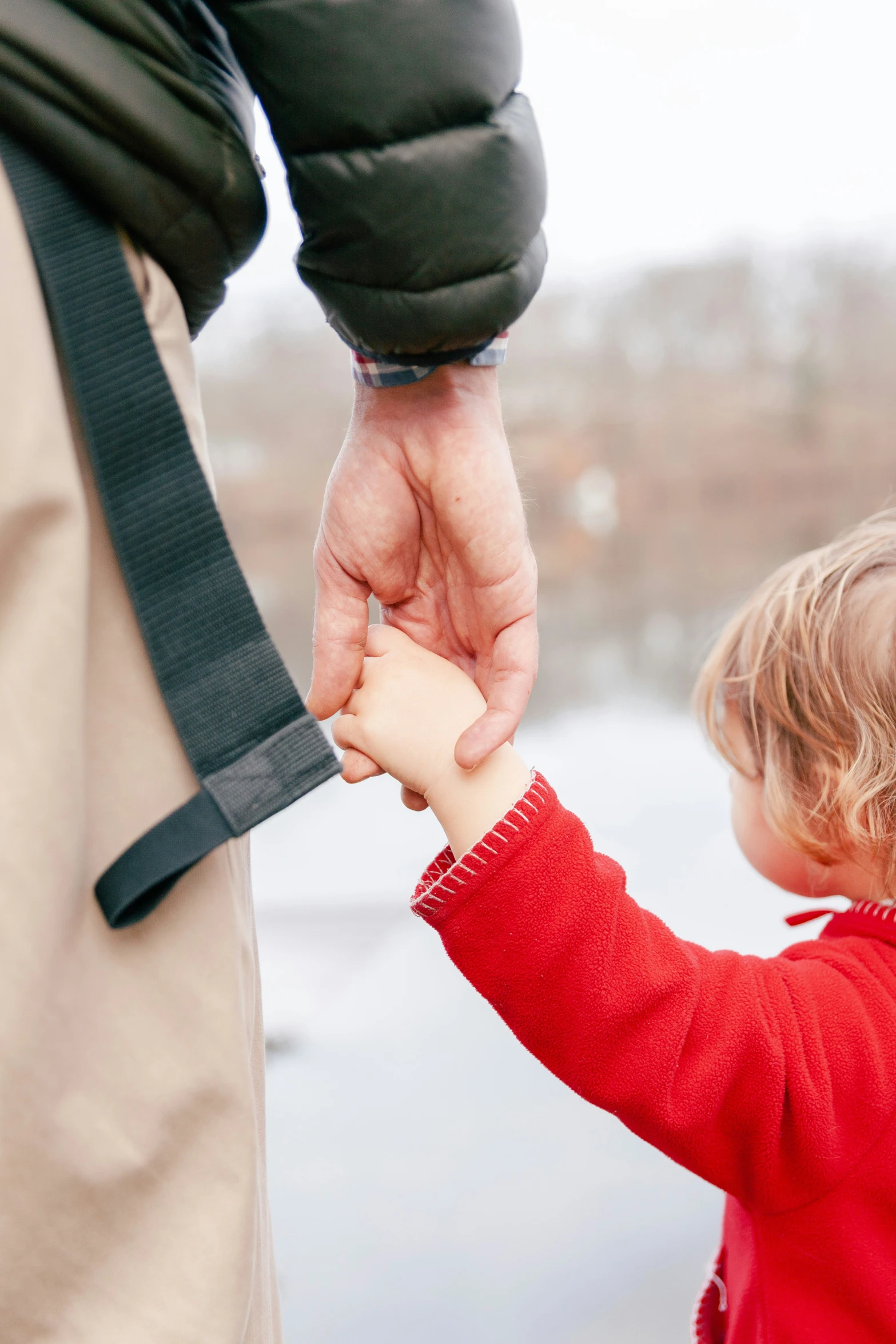 two people hold hands as a child holds it