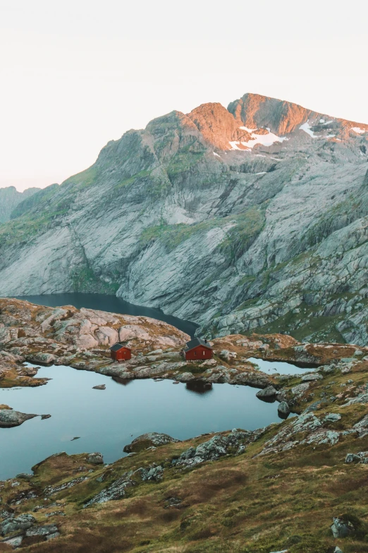 a small lake surrounded by mountains is in the foreground