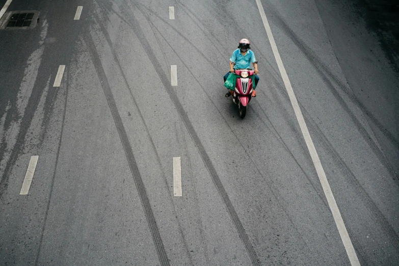 a person on a motor cycle driving down a road