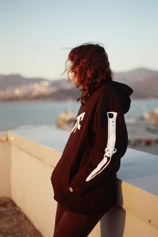 a woman standing on the edge of a building with a camera phone