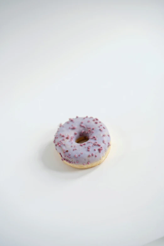 a donut with white and pink icing sits on the table