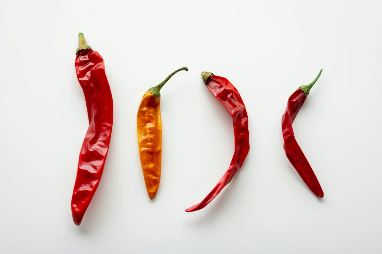 three long red peppers with different angles, the other one is a pepper