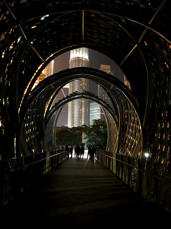 people are walking through a tunnel in the city at night